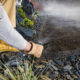 Landscaping Worker Adjusting Garden Water Sprinkler Landscaping Worker Adjusting Garden Water Sprinkler in a Newly Build Residential Backyard Garden. Modern Irrigation Systems. Gardening and Landscaping Theme.